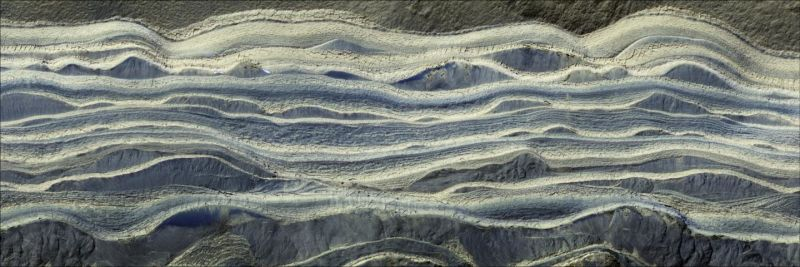Esta imagen muestra capas alternas de hielo y arena en un área donde quedan expuestas sobre la superficie de Marte. El agua helada es de color claro, mientras que la arena es azul oscuro.Imagen: NASA/JPL/University of Arizona